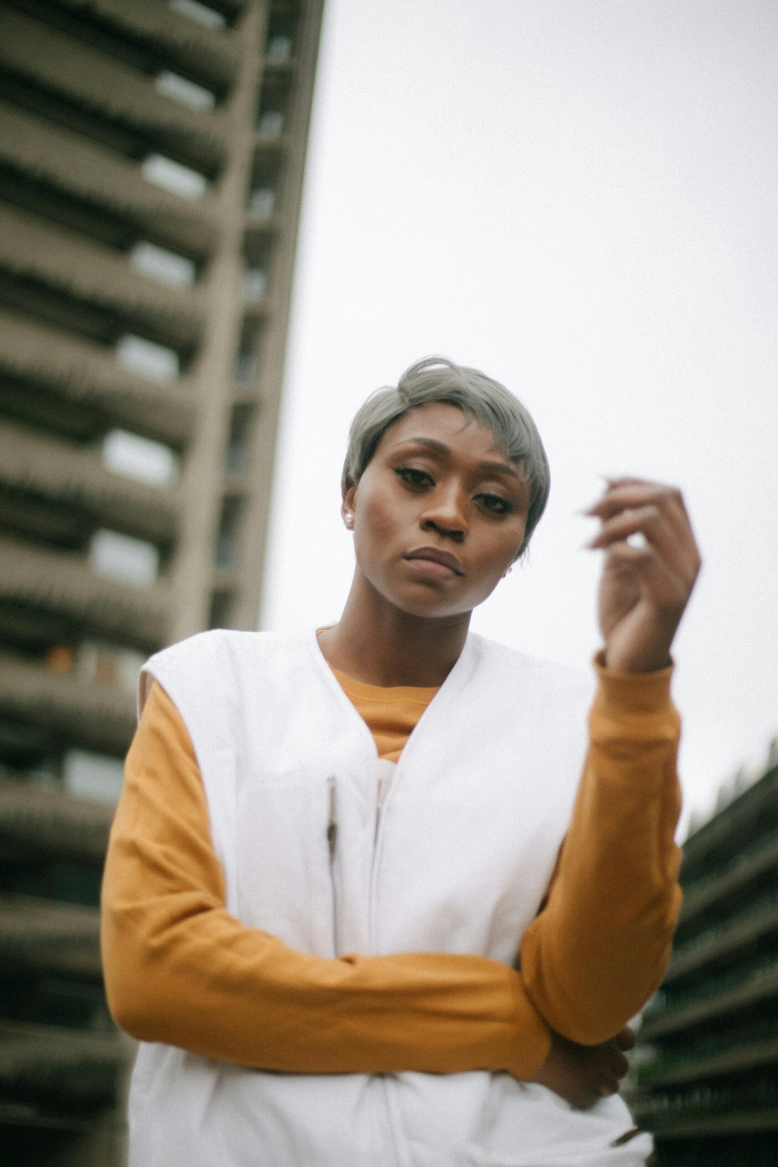 Stylish woman with short hair posing outdoors in urban environment.